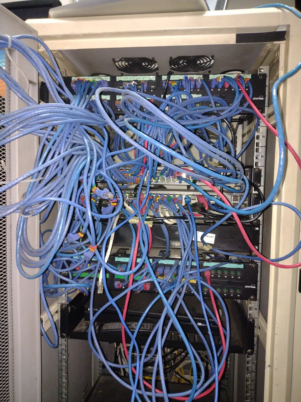 Rack antes de la intervención: patch cords cruzados sin organizadores y puertos sin identificar