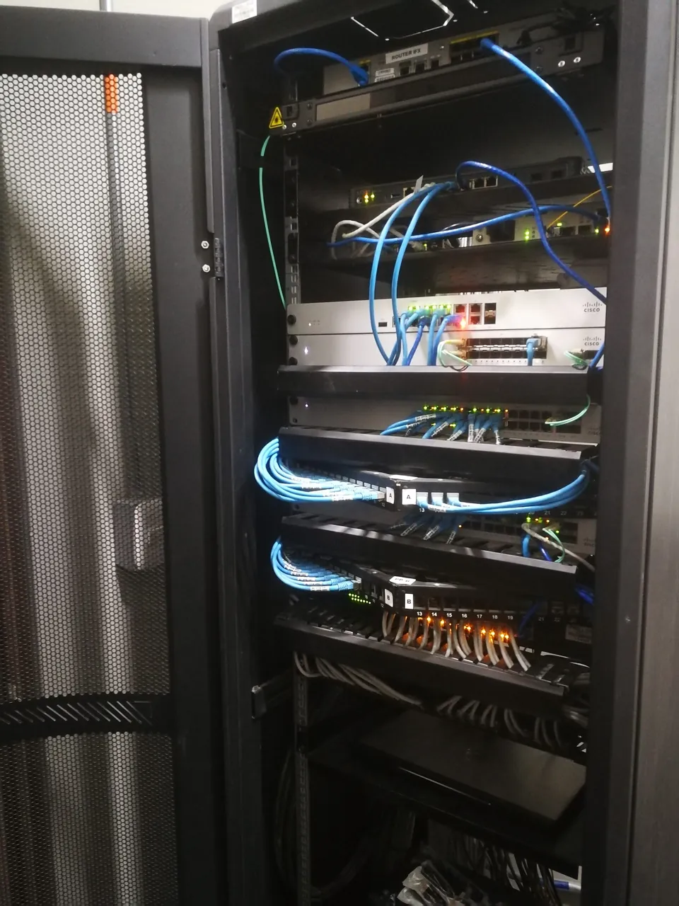 Patch panels con puertos numerados y patch cords peinados hacia los organizadores del rack