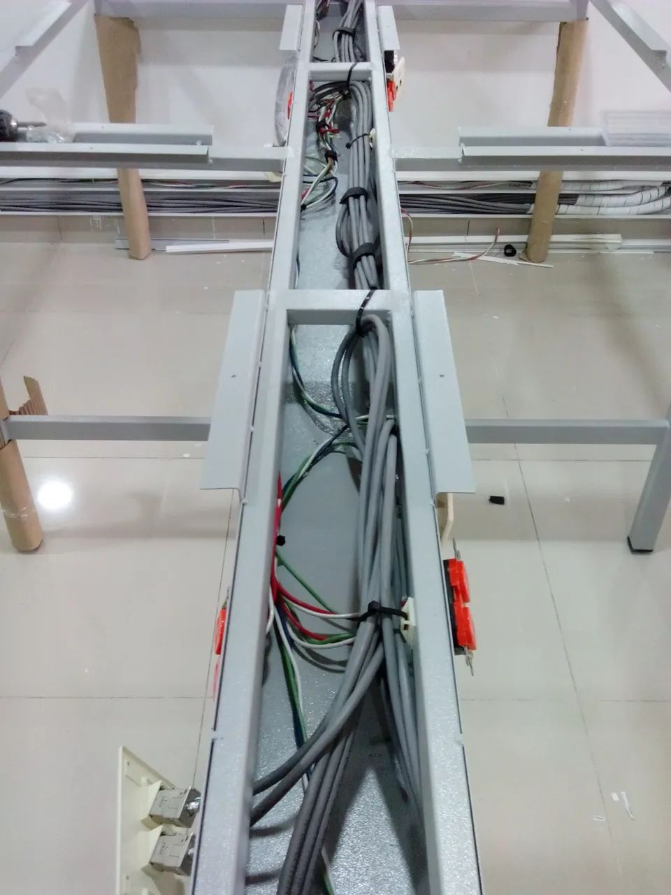 Cableado de datos y eléctrico bajo estaciones de trabajo en isla, antes del cierre de la canaleta