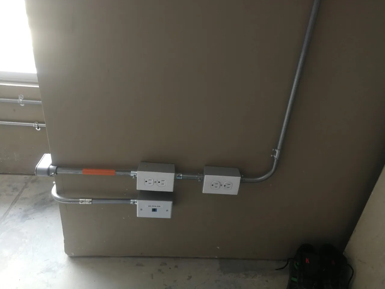 Punto de datos y tomas eléctricas instalados en tubería EMT sobre muro de oficina