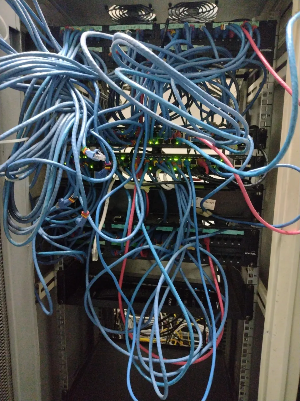 Rack de comunicaciones con cables sin organizar, tal como se encuentra antes de intervenir