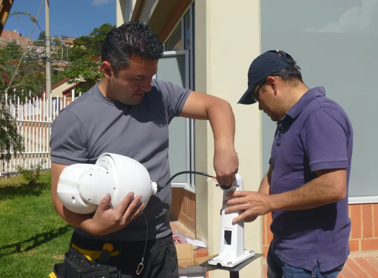 Dos técnicos de RSI ensamblando una cámara PTZ antes de instalarla en fachada