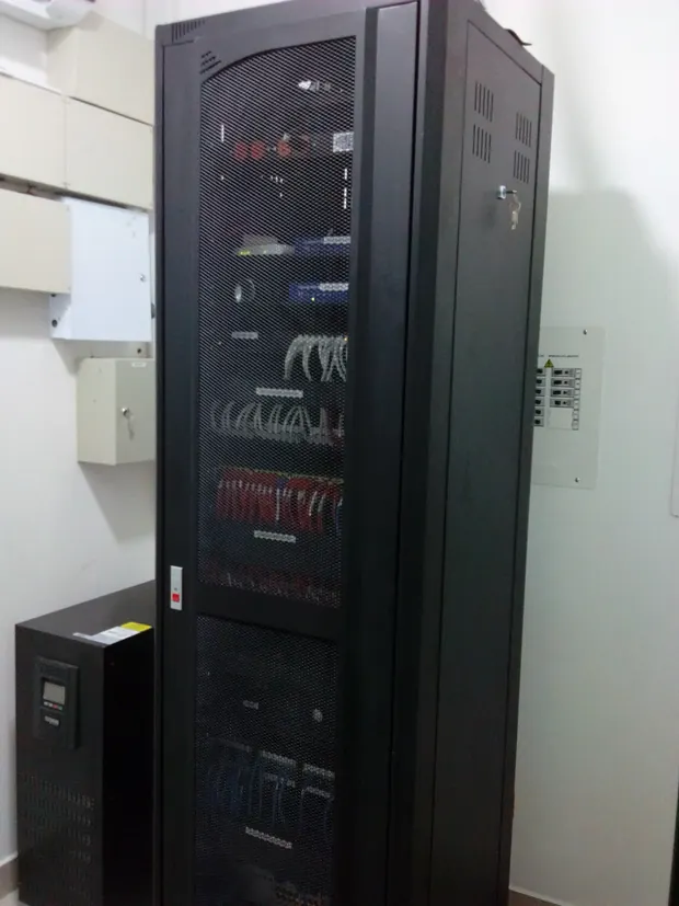 Gabinete de comunicaciones de Efecty en Cali, con puerta de malla, junto a la UPS y al tablero de circuitos regulados