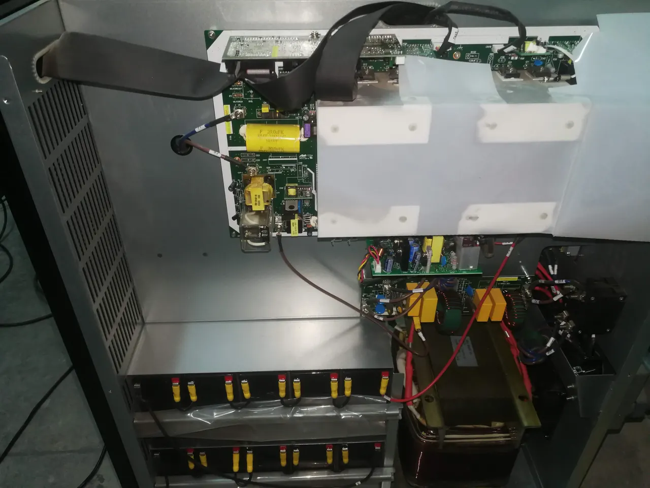 Interior de una UPS abierta durante mantenimiento, con sus tarjetas electrónicas y el banco de baterías a la vista