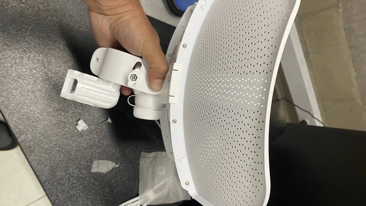 Antena de radioenlace Ubiquiti LiteBeam ensamblándose sobre una mesa de trabajo, con el soporte orientable ya acoplado